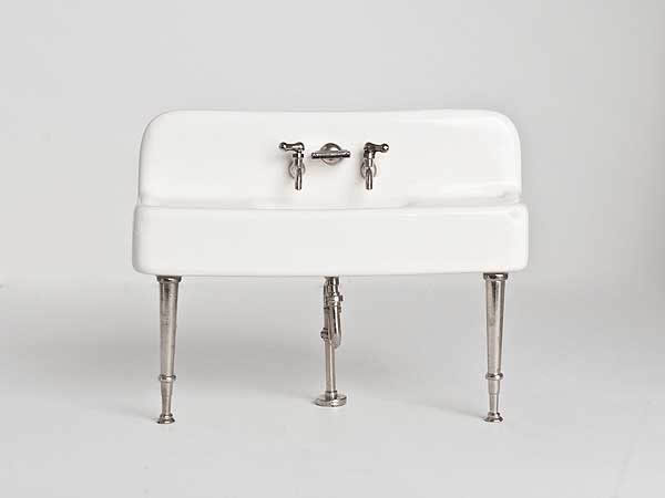White sink with silver taps and legs