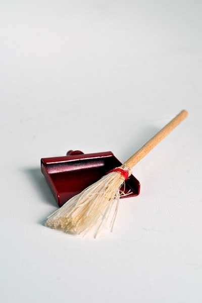 Straw broom and red dust pan