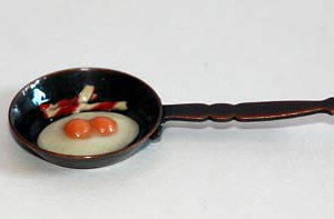 Metal frying pan with eggs and bacon