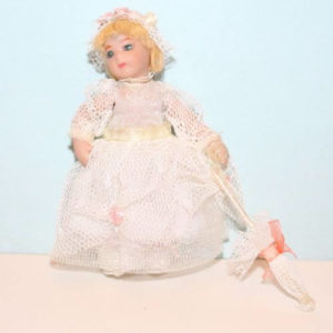 Porcelain doll in white net dress and parasol