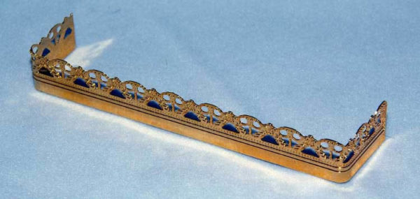Long gold fire fender with ornate edge